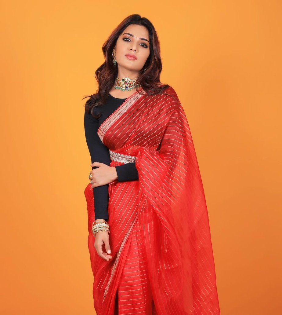 Aatmika pairs her striped red saree with a black blouse and a belt!